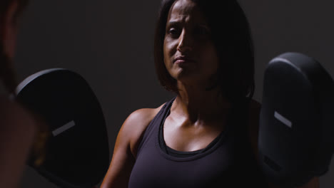 Close-Up-Studio-Shot-Of-Two-Mature-Women-Wearing-Gym-Fitness-Clothing-Exercising-Boxing-And-Sparring-Together-2